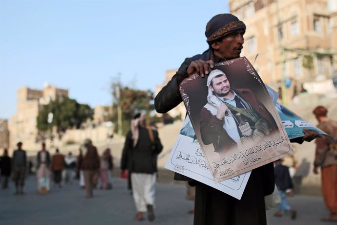 25 January 2021, Yemen, Sanaa: A Yemeni vendor displays portraits of the leader of the Houthis, Abdul-Malik al-Houthi, to sell them for the demonstrators during a rally against the United States over its decision to designate the Houthi rebels movement 