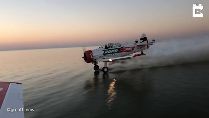 Un grupo de pilotos pone sus aviones en formación para hacer esquí acuático en un lago de Botsuana