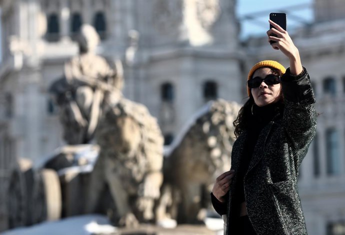 Una mujer se hace un selfie junto a la estatua de Cibeles, en Madrid (España), a 11 de enero de 2021.  