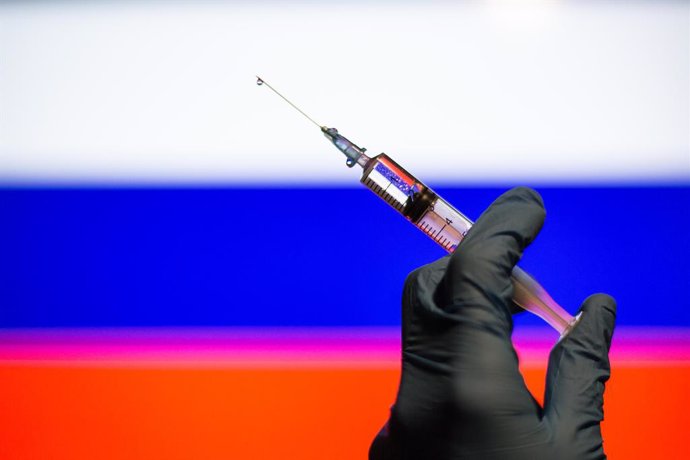 Ilustración de una vacuna con la bandera rusa de fondo