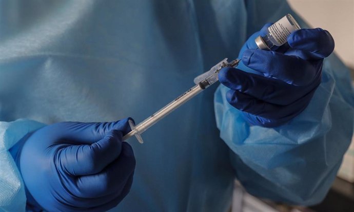 Un sanitario de una residencia inyecta las dosis de la vacuna 