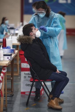 Una trabajadora sanitaria protegida realiza uno de los primeros test de antígenos de SARS-CoV-2 que durante la jornada de hoy efectuarán en el polideportivo del Campus Sur de Vallecas de la Universidad Politécnica a jóvenes de entre 18 y 29 años, en Madri