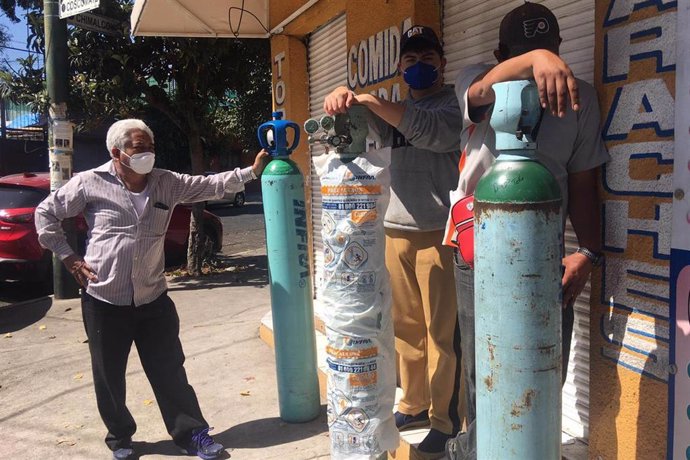 Mexicanos hacen cola para rellenar bombonas de oxígeno en la capital del país.