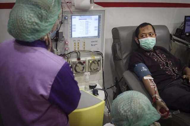 23 December 2020, Indonesia, Malang: A man who recovered from coronavirus (COVID-19), donates blood plasma at the Red Cross office in Malang.