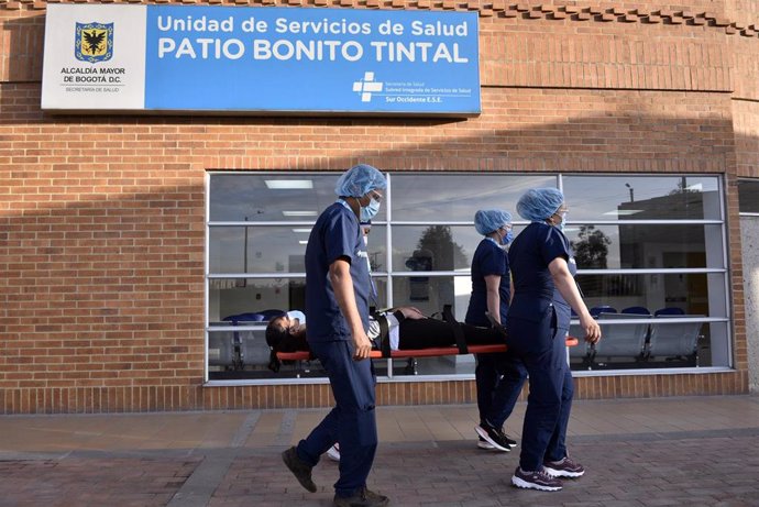 Cuatro sanitarios llevan en camilla a un paciente en Bogotá durante un ensayo de cara al comienzo de las vacunaciones contra el coronavirus en el país, que empezarán el próximo 20 de febrero.