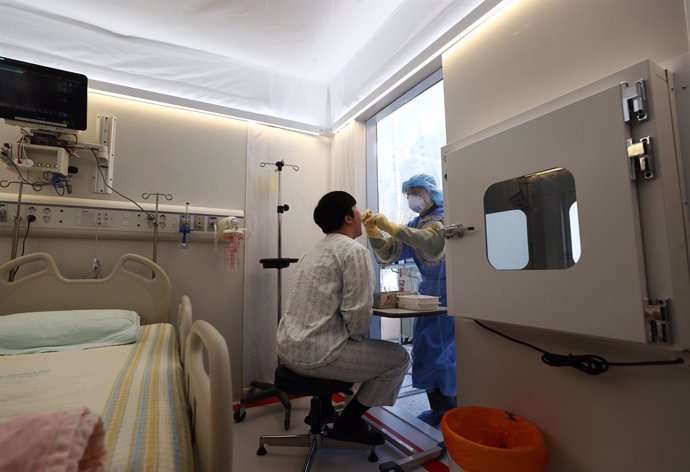 07 January 2021, South Korea, Seoul: A medical worker simulates taking a sample from a mock coronavirus (COVID-19) patient in a mobile negative pressure room set up in front of the Korea Cancer Center Hospital for serious coronavirus (COVID-19) patients