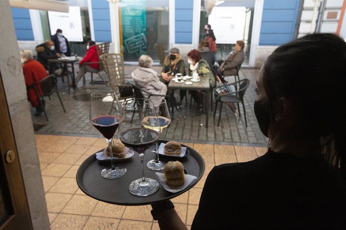 Una camarera se dispone a servir en una terraza de un restaurante