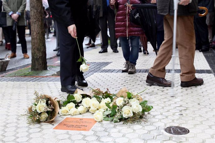 Una persona coloca una flor ante la placa conmemorativa de Fernando Múgica Herzog en San Sebastián, Euskadi (España), a 6 de febrero de 2021. El Ayuntamiento de San Sebastián ha colocado este sábado una placa en memoria del abogado e histórico militante