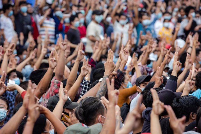 06 February 2021, Myanmar, Yangon: Protesters flash the three fingers salute during a demonstration at the Sule Pagoda against the military coup in Myanmar. Myanmar's military seized power on 1 February 2021 and detained government officials including t