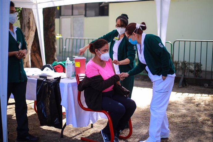 Una sanitaria recibe la vacuna en México.