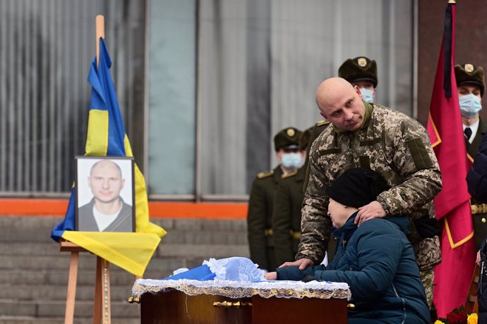 14 January 2021, Ukraine, Zaporizhzhia: People pay their respects to perished soldier Oleh Andriienko during his funeral ceremony outside the Zaporizhzhia Regional State Administration. The 37-year-old serviceman was shot dead by a sniper near the Pisky
