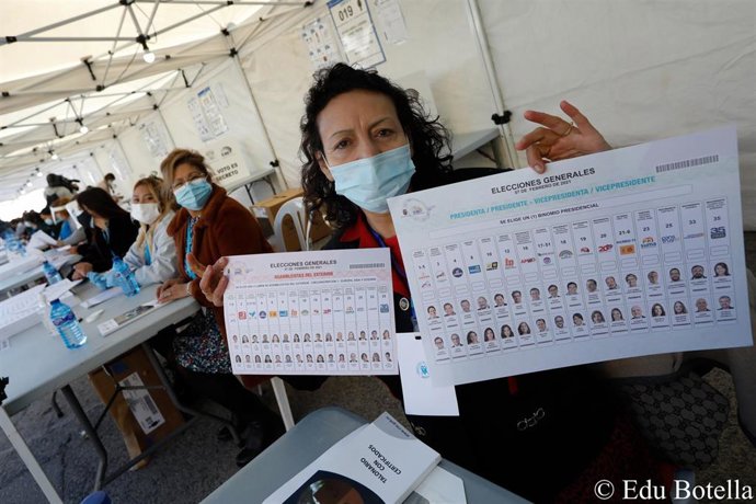 Una mujer procedente de Ecuador posa con todos los candidatos a la presidencia de la República de Ecuador en Murcia
