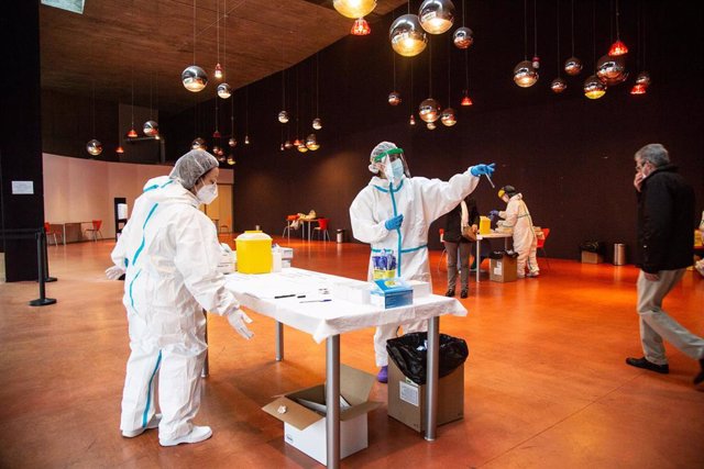 Profesionales sanitarios participan en un cribado masivo de test de antígenos en el palacio congresos de Badajoz.