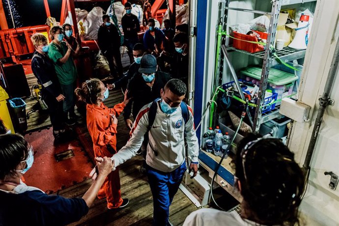 HANDOUT - 06 July 2020, Italy, Porto Empedocle: Migrants leave the rescue ship of the humanitarian group SOS Mediterranee "Ocean Viking". 180 Migrants stranded on board for days, has finally transferred to an Italian quarantine ferry.. Photo: Flavio Gas
