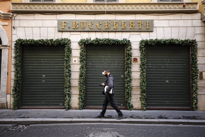 24 December 2020, Italy, Rome: A man walks past closed shops in Via Condotti street amid the Coronavirus lockdown during Christmas. Photo: Cecilia Fabiano/LaPresse via ZUMA Press/dpa
