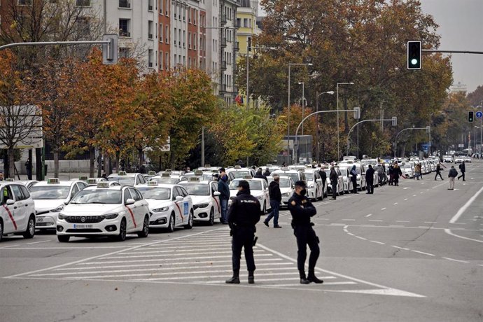 Agentes de la Policía Nacional controlan una marcha de taxistas convocada por la FPTM, la Asociación Gremial del Taxi de Madrid y la Asociación Élite Taxi Madrid, en Madrid (España), a 25 de noviembre de 2020. El taxi de Madrid se moviliza para exigir a