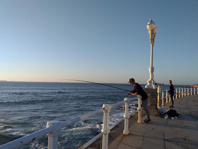 Pescador en la playa de San Lorenzo de Gijón