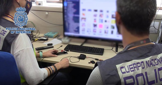 Imagen de archivo de agentes de Policía Nacional investigando en un ordenador 