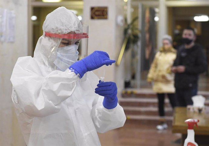03 February 2021, Slovakia, Kosice: A nurse in a protective suit cheks a swab during antigen testing at the collection point at the Koicky hospital. Photo: Franti?ek Iván/TASR/dpa