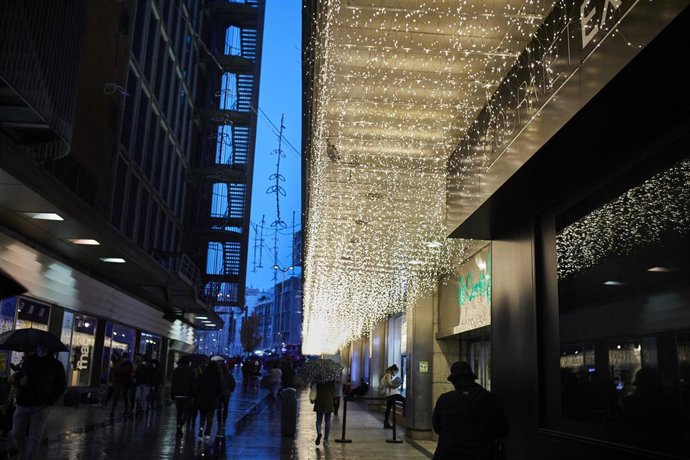 Transeúntes caminan cerca de una zona comercial en la calle de Preciados, en Madrid  