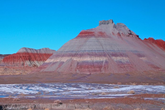 Las elevaciones con bandas coloridas son parte del miembro Blue Mesa, una característica geológica de entre 220 millones y 225 millones de años en la Formación Chinle en el Parque Nacional del Bosque Petrificado en Arizona.