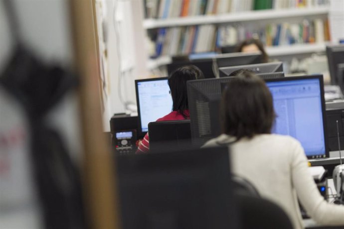 Trabajadores con ordenadores en una oficina.