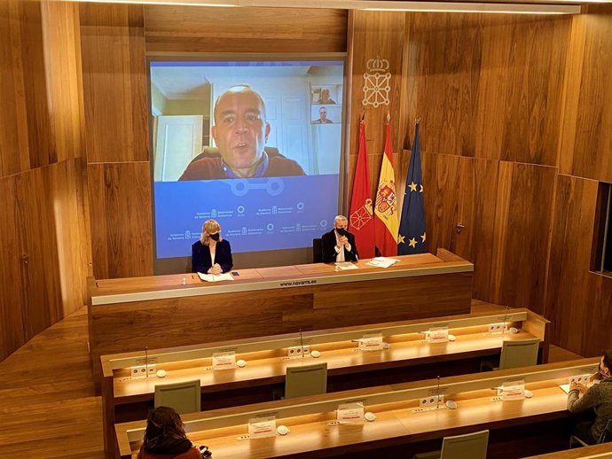 La consejera Ollo y el director general, Martín Zabalza,  con el director del informe, Javier Dorado en pantalla, durante la comparecencia de prensa