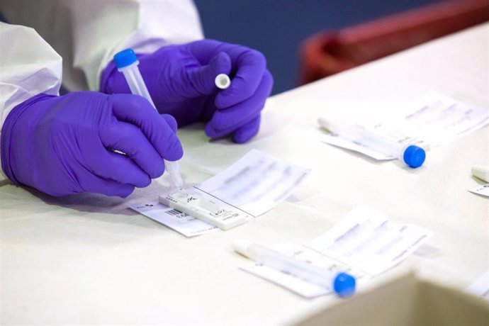 Un trabajador sanitario sostiene una de las probetas utilizadas para realizar un test de antígenos