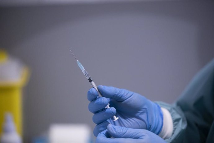Un sanitario manipula una jeringa con la vacuna de Pfizer / BioNtech contra la Covid-19, foto de archivo