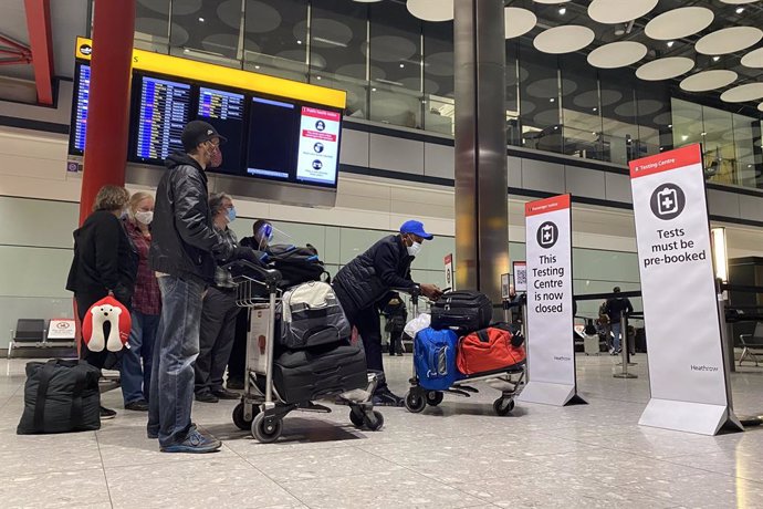 18 January 2021, United Kingdom, London: Passengers wait in a line outside the testing centre in the arrival hall of Terminal 5 at London's Heathrow Airport, passengers arriving from anywhere outside the UK must have proof of a negative coronavirus test