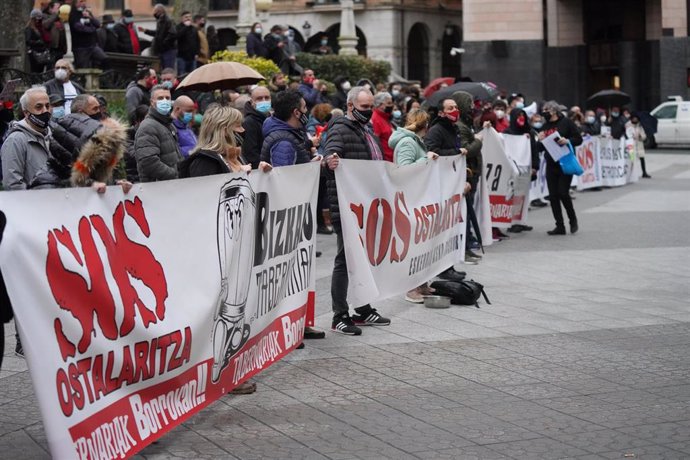 Un grupo de personas perteneciente al sector hostelero de Vizcaya participa en la concentración convocada en el Juzgado en Bilbao para solicitar la reapertura de los establecimientos, en el Palacio de Justicia, Bilbao, País Vasco, (España).