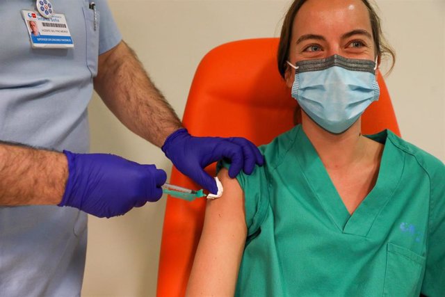 Un trabajador sanitario inyecta una dosis de la de Pfizer-BioNTech contra la Covid-19 a una sanitaria del Hospital Infanta Sofía de San Sebastián de los Reyes.
