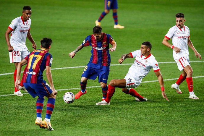 10 Lionel Messi of FC Barcelona defended by 20 Diego Carlos of Sevilla FC during La Liga match between FC Barcelona and Sevilla FC at Camp Nou Stadium on October 04, 2020 in Barcelona, Spain.