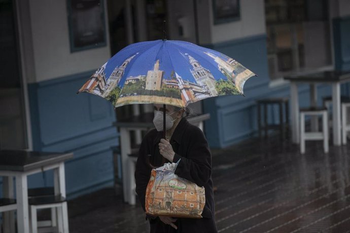 Una mujer camina bajo su paraguas durante un día lluvioso 