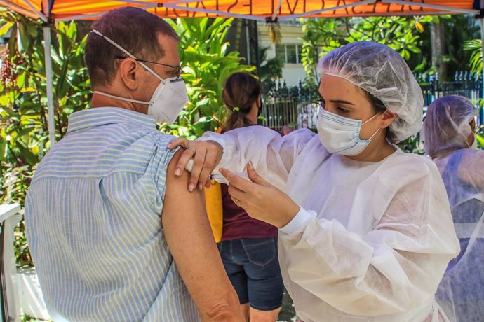 27 January 2021, Brazil, Rio de Janeiro: A healthcare worker administers the Oxford-AstraZeneca vaccine to a man. Photo: Ellan Lustosa/ZUMA Wire/dpa
