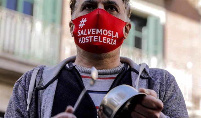 Un hombre con una mascarilla en la que se lee: `Salvemos la hostelería durante la cacerolada promovida por La Coordinadora Empresarial del Ocio y la Hostelería contra el cierre de la hostelería en la Comunidad Valenciana, en Valencia (España), a 21 de en