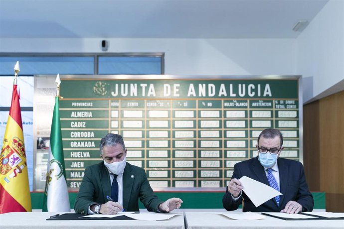 El consejero de Presidencia, Administración Pública e Interior, Elías Bendodo (i), y el expresidente de la Junta de Andalucía, José Rodríguez de la Borbolla (d) durante la firma de un convenio de colaboración para finalizar la digitalización del archivo