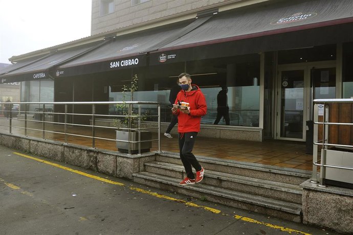 Un joven recoge un café de un establecimiento abierto en San Cibrao das Viñas, en Ourense, el pasado mes de noviembre.