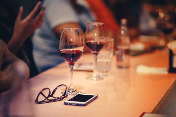 Teléfonos móvil y copas de vino.