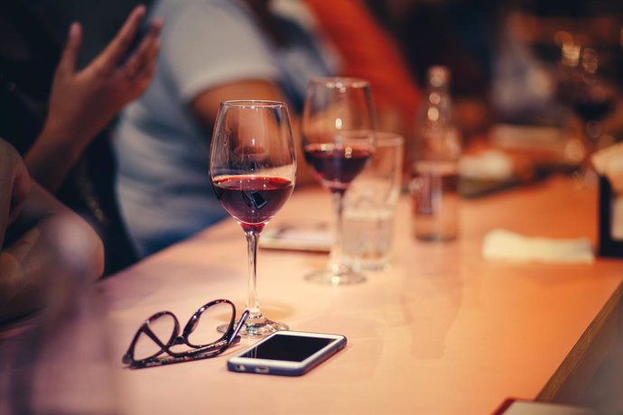 Teléfonos móvil y copas de vino.