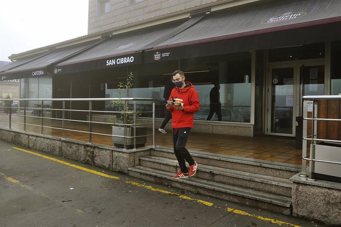 Un joven recoge un café de un establecimiento abierto en San Cibrao das Viñas, en Ourense, el pasado mes de noviembre.