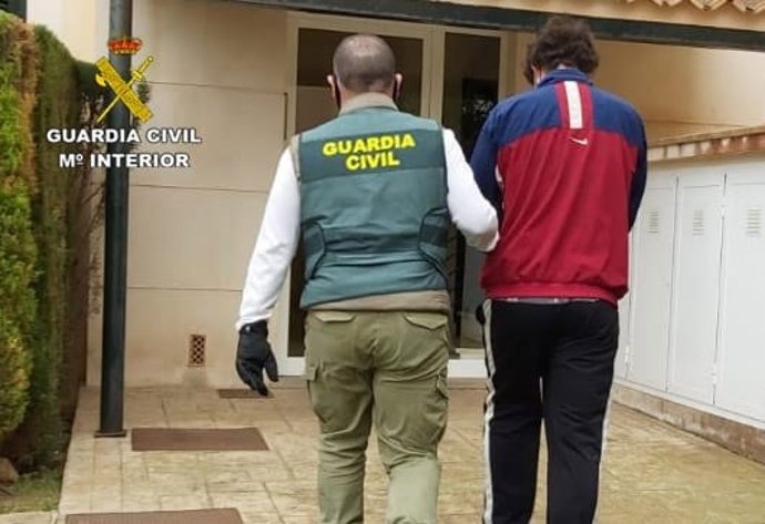 Un agente de la Guardia Civil con el joven detenido en Llucmajor por varios robos en vehículos.