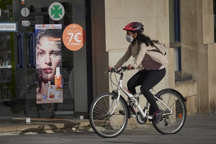 Una mujer con mascarilla y bici en una céntrica calle de Pamplona, Navarra (España) a 17 de julio de 2020. Este viernes a las 00.00 horas ha entrado en vigor la orden foral que obliga a los ciudadanos mayores de 12 años a usar mascarilla en Navarra aunq