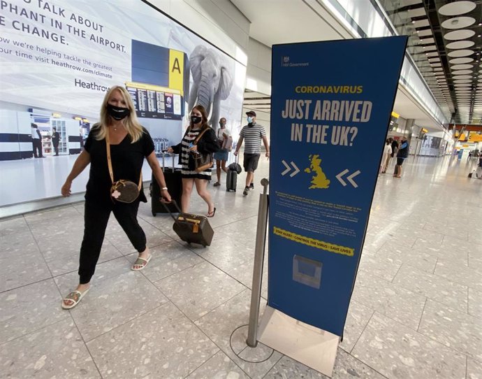 Pasajeros con mascarilla en el Aeropuerto de Heathrow, en Londres, durante la pandemia de COVID-19. 