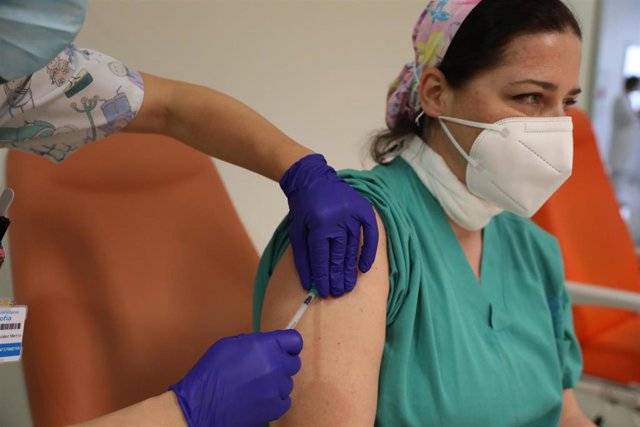 Un trabajador sanitario inyecta una dosis de la de Pfizer-BioNTech contra la Covid-19 a una sanitaria del Hospital Infanta Sofía de San Sebastián de los Reyes.