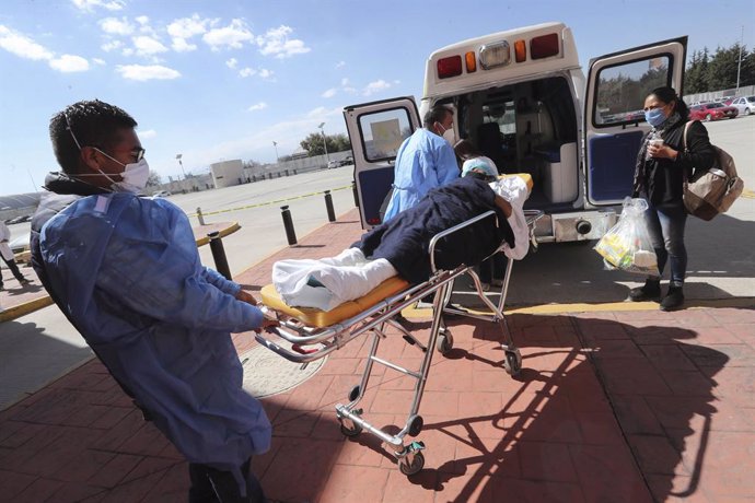 04 January 2021, Mexico, Toluca: Health workers transport a patient to an ambulance, the government of the State of Mexico has put into operation a temporary rehabilitation unit for non-Covid-19 patients in the Toluca Convention and Exhibition Centre du