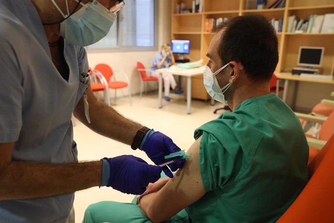 Un trabajador sanitario inyecta una dosis de la de Pfizer-BioNTech contra la Covid-19 a un sanitario del Hospital Infanta Sofía de San Sebastián de los Reyes, Madrid (España), a 9 de febrero de 2021. Los sanitarios comenzaron a vacunarse en el hospital 