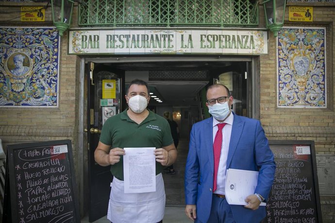 El propietario del bar La Esperanza, Jesús Noguera (i) y su abogado Germán Grima en la puerta del establecimiento antes de su cierre