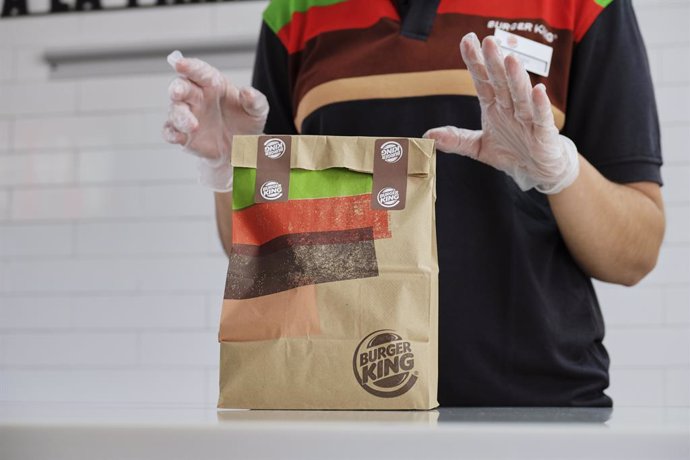 Una empleada protegida con pantalla, mascarilla y guantes prepara un pedido en un establecimiento de Burger King, dentro del plan Más Seguro que nunca que la cadena ha puesto en marcha en todos sus establecimientos abiertos con una serie de estrictas me