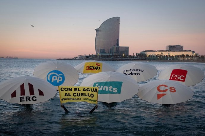 Han situado en el agua siete sombrillas de playa con los logos de los partidos políticos con representación parlamentaria en Catalunya, simulando que son engullidas por la subida del nivel del mar